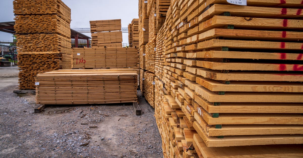 High stacks of wooden planks stored outdoors in a lumber yard.