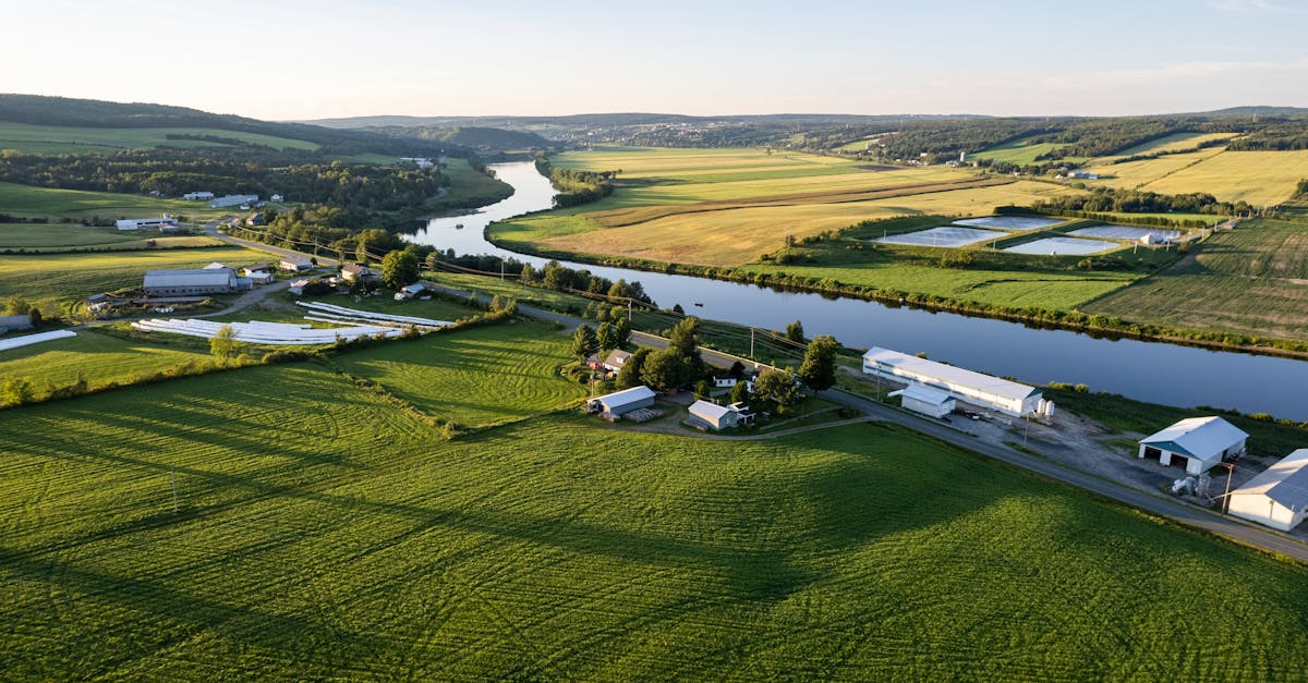 A serene aerial landscape showing lush farmlands along the river in Quebec.